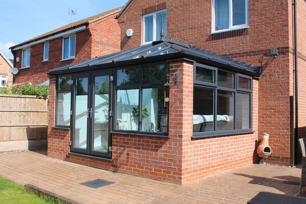 A conservatory with a new grey tiled warm roof